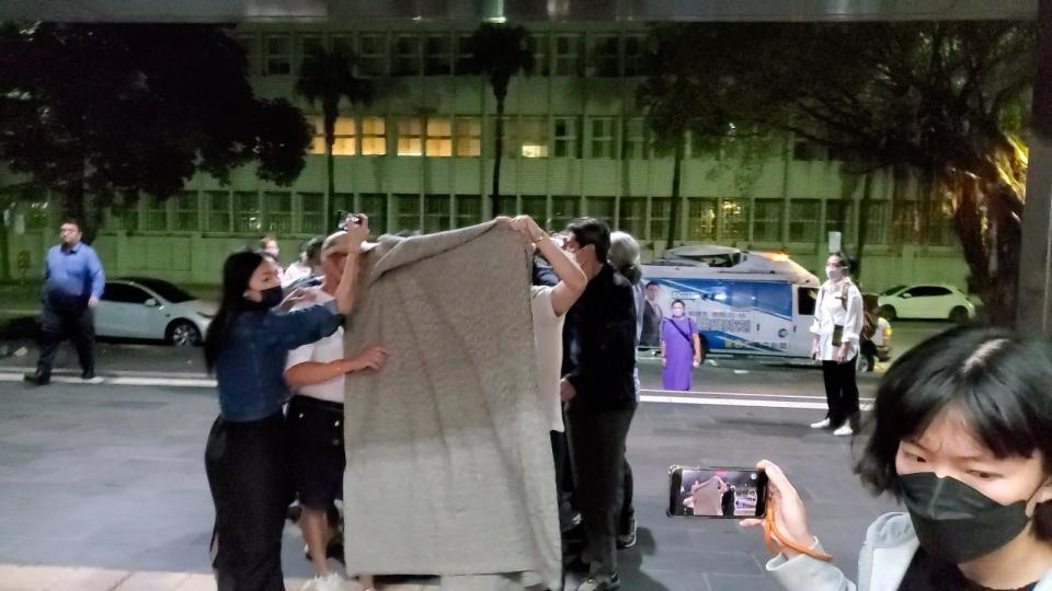 當警方將呂秀金移送北檢時，大批親友蜂擁而上，甚至拿起一張大毛毯幫她遮住。資料照。呂志明攝