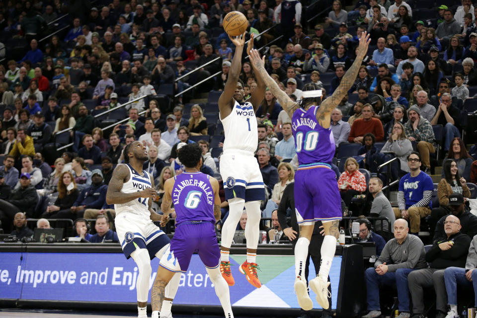 Minnesota Timberwolves guard Anthony Edwards (1) shoots a 3-point basket over Utah Jazz guards Jordan Clarkson (00) and Nickeil Alexander-Walker (6) with Timberwolves forward Taurean Prince (12) looking on in the fourth quarter of an NBA basketball game Monday, Jan. 16, 2023, in Minneapolis. (AP Photo/Andy Clayton-King)