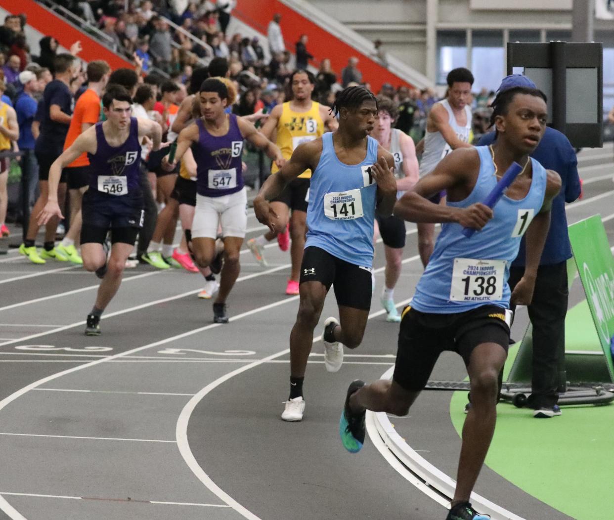 Alexander Hamilton's Carlyle Roberts (l) slows after handing the baton off to Nanuet’s Jarell Gibbs (r) as the two race for Section One in the boys distance medley relay at the 2024 New York State Indoor Track and Field Championships at the Ocean Breeze Athletic Complex in Staten Island, March 2, 2024.