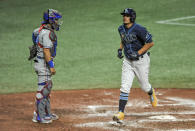 Texas Rangers catcher Jose Trevino watches as Tampa Bay Rays' Willy Adames, right, scores on a solo home run off Rangers Taylor Hearn during the eighth inning of a baseball game Monday, April 12, 2021, in St. Petersburg, Fla. (AP Photo/Steve Nesius)