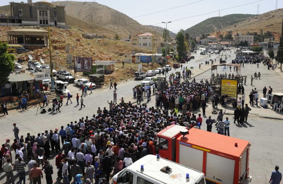 Syrians living in Lebanon line up as they wait to cross the Masnaa border crossing between Lebanon and Syria to vote in the presidential election June 3, 2014. Syrians voted on Tuesday in an election expected to deliver an overwhelming victory for President Bashar al-Assad in the midst of a devastating civil war but which his opponents have dismissed as a charade. (REUTERS/Hassan Abdallah)