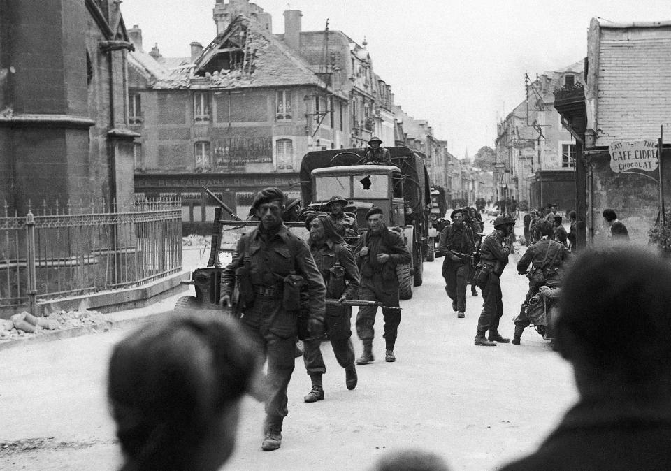 FILE - British Commandos pass through the streets of a town near Caen, in Normandy, France, on June 6, 1944. Following the initial landings on the French coast, Allied troops at once began to push inland. Passing through Normandy villages they were given warm welcome by the inhabitants. (AP Photo, File)