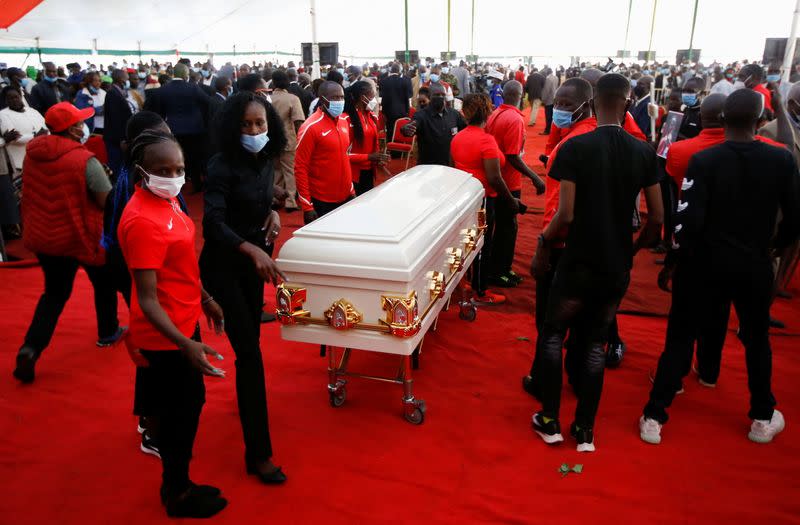 Kenyan athletes place the coffin of long-distance runner Agnes Tirop before her funeral service at Kapnyamisa village