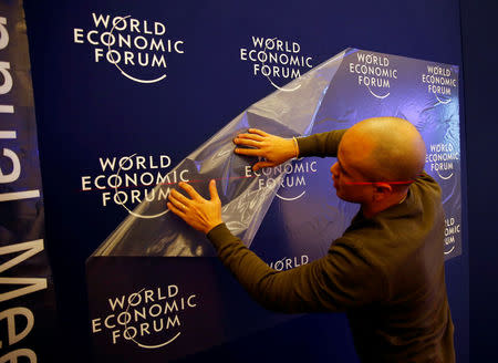 A worker prepares the logo of the World Economic Forum in the congress center of the annual meeting of the World Economic Forum (WEF) in Davos, Switzerland January 16, 2017. REUTERS/Ruben Sprich