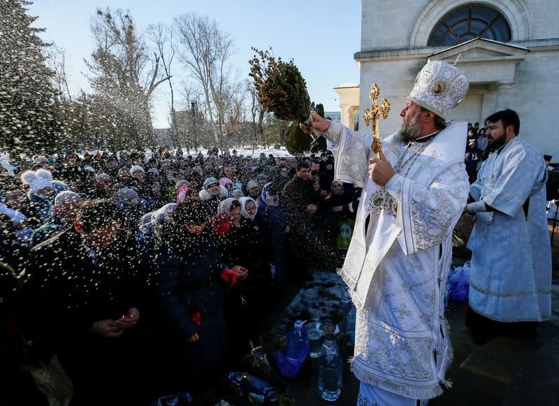 FILE PHOTO: Metropolitan of Chisinau and All Moldova Vladimir splashes water on believers during Orthodox Epiphany celebrations in Chisinau