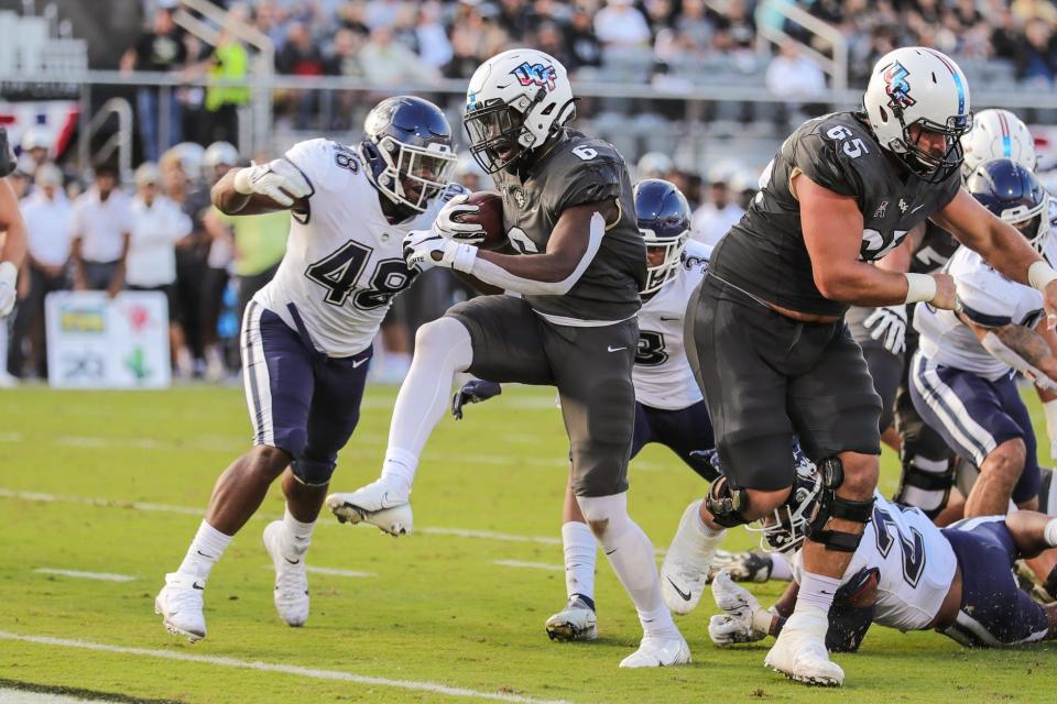 UCF Knights running back Mark-Antony Richards (6) scores a touchdown during the first quarter against Connecticut Huskies as Cole Schneider sets to block at Bounce House in Orlando.