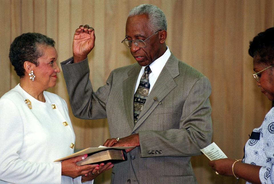 The Rev. Leon L. Troy Sr. (center) is sworn in as a new member of the Columbus Board of Education in 1996. His wife, Berniece, holds the Bible while board member Loretta Heard swears him in.