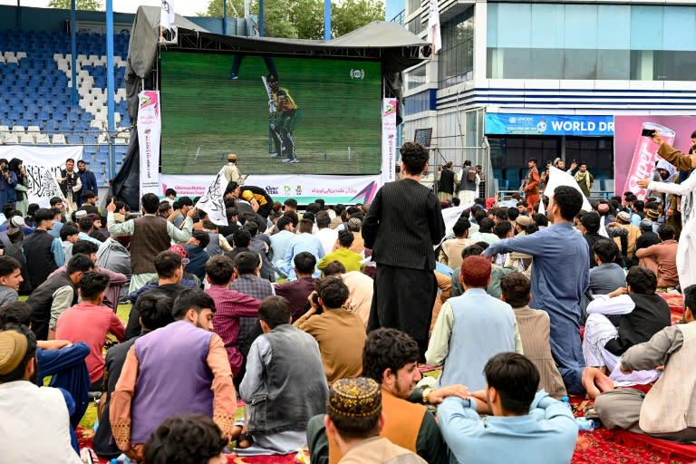 Des supporters afghans massés devant un écran géant à Kaboul pour suivre le match de leur équipe de Cricket contre l'Afrique du Sud, le 27 juin 2024 (Wakil KOHSAR)