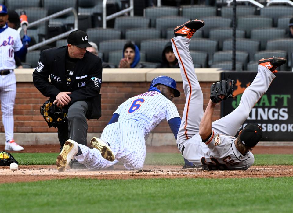 San Francisco Giants starting pitcher Alex Cobb, right, falls over New York Mets runner Starling Marte (6) who scored on a wild pitch during the first inning of the first game of a baseball double-header Tuesday, April 19, 2022, in New York.