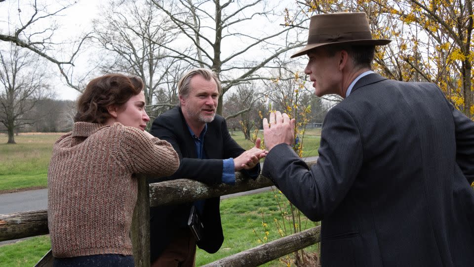 Emily Blunt (as Kitty Oppenheimer) with writer, director, and producer Christopher Nolan and Cillian Murphy (as J. Robert Oppenheimer) on the set of "Oppenheimer." - Melinda Sue Gordon/Universal Pictures