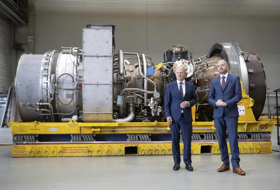 German Chancellor Olaf Scholz, left, stands besides Christian Bruch, CEO of Siemens Energy, at the turbine serviced in Canada for the Nordstream 1 natural gas pipeline in Muelheim an der Ruhr, Germany, Aug. 3, 2022. German Chancellor Olaf Scholz visited a plant by Siemens Energy where a turbine, which is at the center of a dispute between Germany and Russia over reduced gas supplies, is currently sitting in storage until it can be shipped to Russia. (Bernd Thissen/dpa via AP)