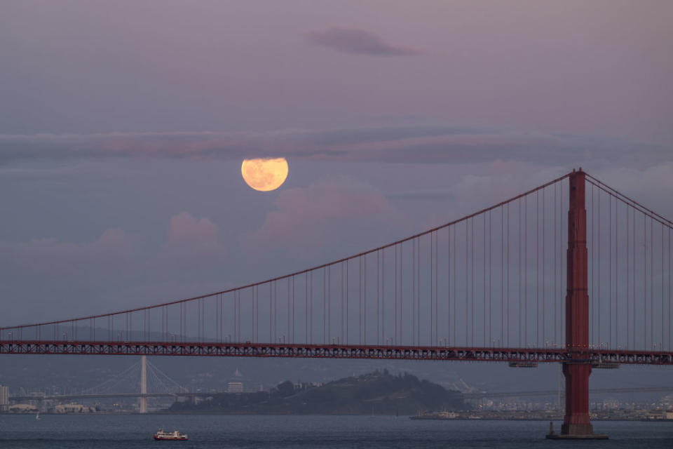 A bright full moon over the red suspension bridge