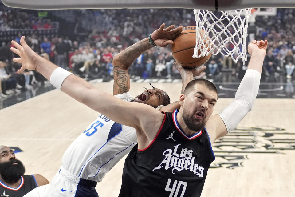Dallas Mavericks forward Derrick Jones Jr., center, shoots as Los Angeles Clippers guard James Harden, left, and center Ivica Zubac defend during the first half in Game 2 of an NBA basketball first-round playoff series Tuesday, April 23, 2024, in Los Angeles. (AP Photo/Mark J. Terrill)