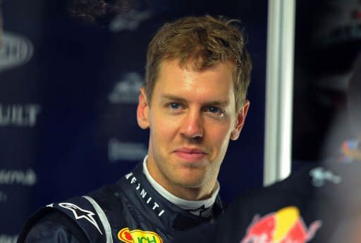 Red Bull-Renault driver Sebastian Vettel of Germany smiles while talking to team members during the second practice session of Formula One's Singapore Grand Prix in Singapore. Vettel posted the fastest time for Red Bull in Friday's second free practice session but played down its likely impact on his chances of retaining his title in Singapore