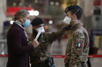 Police officers and soldiers check passengers leaving from Milan main train station, Italy, Monday, March 9, 2020. Italy took a page from China's playbook Sunday, attempting to lock down 16 million people — more than a quarter of its population — for nearly a month to halt the relentless march of the new coronavirus across Europe. Italian Premier Giuseppe Conte signed a quarantine decree early Sunday for the country's prosperous north. Areas under lockdown include Milan, Italy's financial hub and the main city in Lombardy, and Venice, the main city in the neighboring Veneto region. (AP Photo/Antonio Calanni)