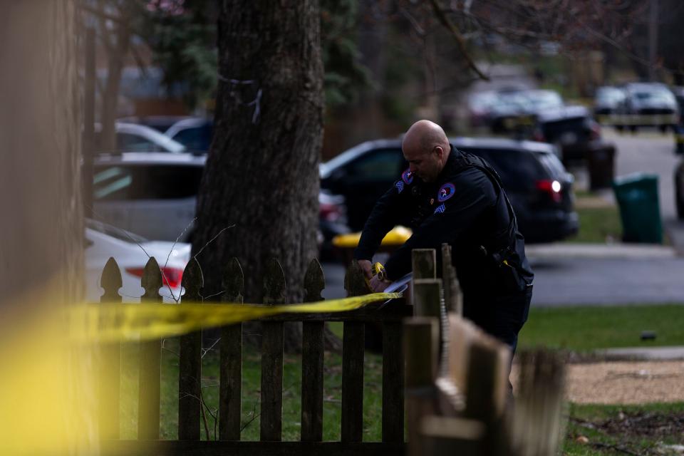 A police officer rolls out crime scene tape on Wednesday, March 27, 2024, near Cleveland Avenue in Rockford.