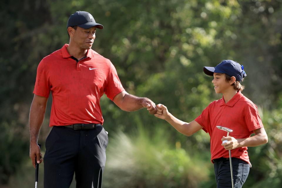 Tiger Woods and Charlie Woods celebrate a birdie on the 12th hole during the final round of the PNC Championship at the Ritz Carlton Golf Club Grande Lakes on December 19, 2021 in Orlando, Florida.