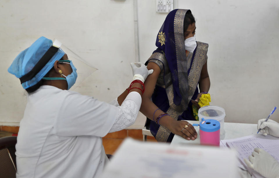 A woman receives the AstraZeneca vaccine for COVID-19 at a hospital in Prayagraj, India. Saturday, May 1, 2021. In hopes of taming a monstrous spike in COVID-19 infections, India opened vaccinations to all adults Saturday, launching a huge inoculation effort that was sure to tax the limits of the federal government, the country's vaccine factories and the patience of its 1.4 billion people. (AP Photo/Rajesh Kumar Singh)