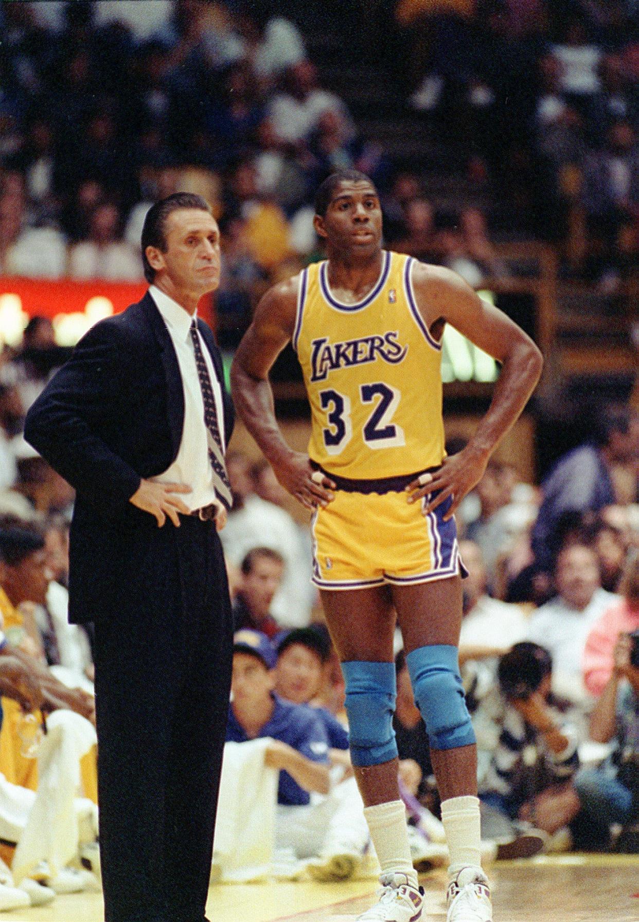 Pat Riley talks with Magic Johnson as coach of the Los Angeles Lakers in 1990.