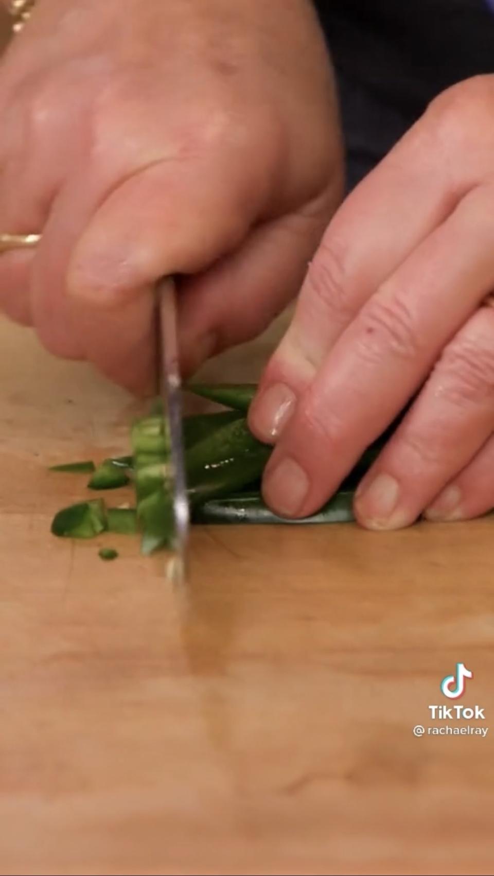 Hands chopping a jalapeño