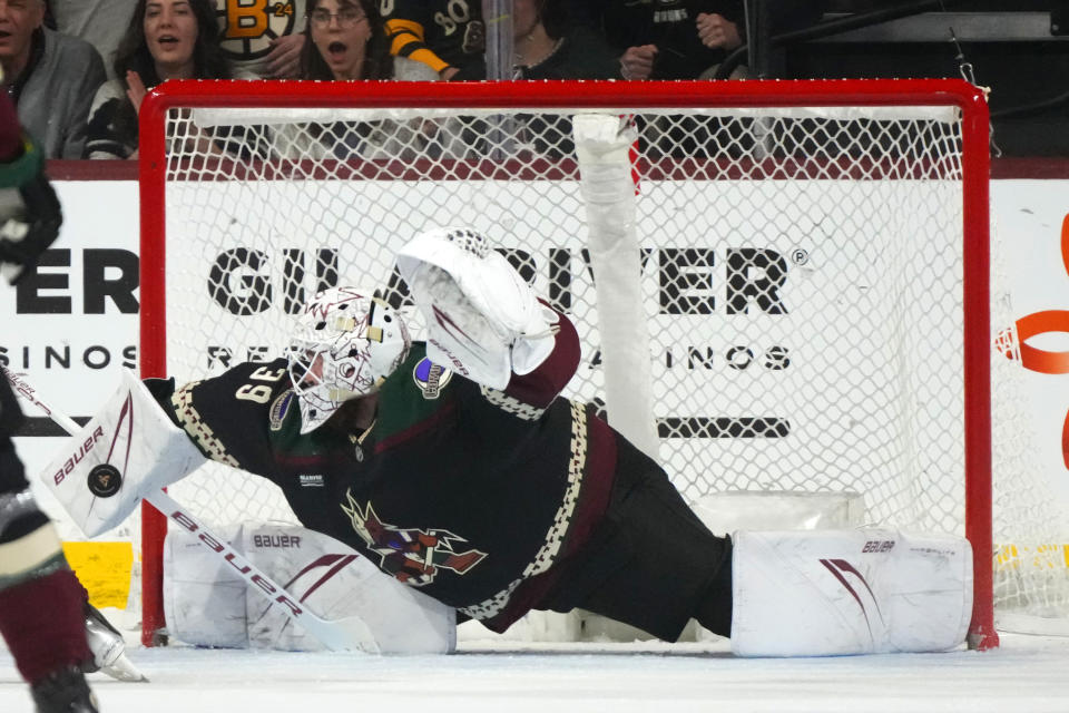 Arizona Coyotes goaltender Connor Ingram makes a glove save against the Boston Bruins during the third period of an NHL hockey game Tuesday, Jan. 9, 2024, in Tempe, Ariz. The Coyotes won 4-3 in overtime. (AP Photo/Ross D. Franklin)