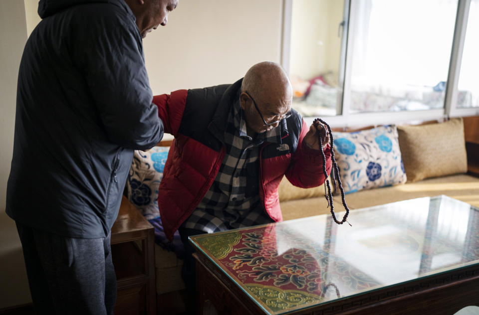 Kanchha Sherpa, right, is helped by his son Tsering Sherpa before an interview with Associated Press at his residence in Kathmandu, Nepal, Saturday, March 2, 2024. Kanchha Sherpa, 91, was among the 35 members in the team that put New Zealander Edmund Hillary and his Sherpa guide Tenzing Norgay atop the 8,849-meter (29,032-foot) peak on May 29, 1953. (AP Photo/Niranjan Shrestha)