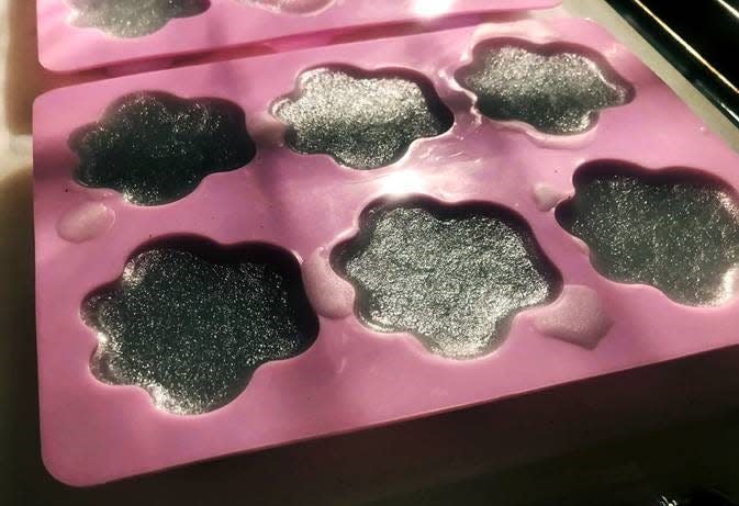 The wax melt making process is very similar to the candle making process with one major difference; the use of molds instead of mason jars. Pictured here is a set of wax melts having been just poured into the mold that creates paw print shaped melts; a fitting shape for a company designed around the love of kitty cats.
