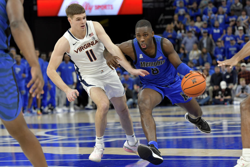 Memphis forward David Jones (8) handles the ball against Virginia guard Isaac McKneely (11) during the first half of an NCAA college basketball game Tuesday, Dec. 19, 2023, in Memphis, Tenn. (AP Photo/Brandon Dill)