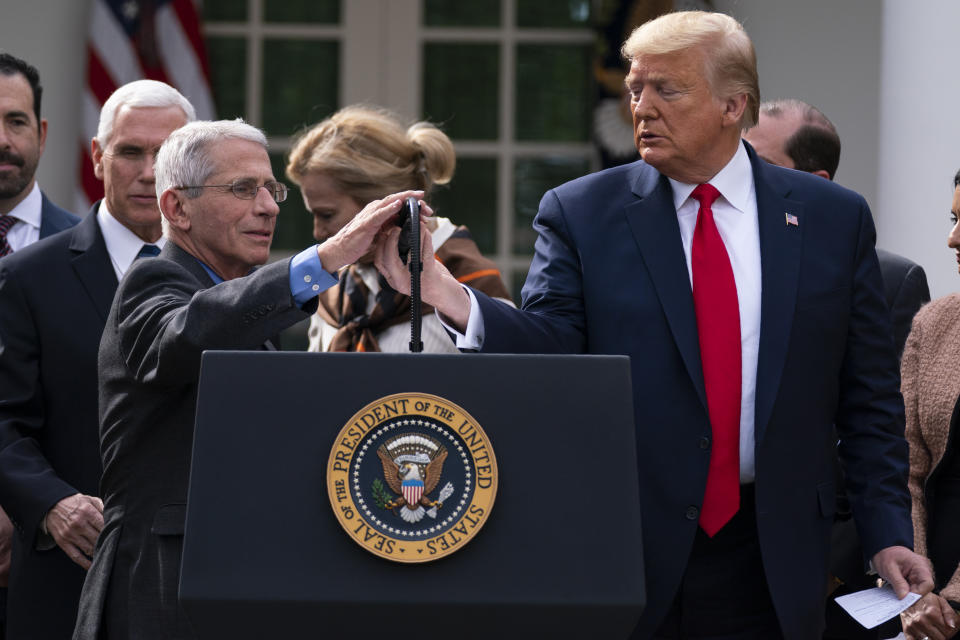 Dr. Anthony Fauci, director of the National Institute of Allergy and Infectious Diseases, adjusts the microphone to speak during a news conference on the coronavirus with President Donald Trump in the Rose Garden at the White House, Friday, March 13, 2020, in Washington. (AP Photo/Evan Vucci)