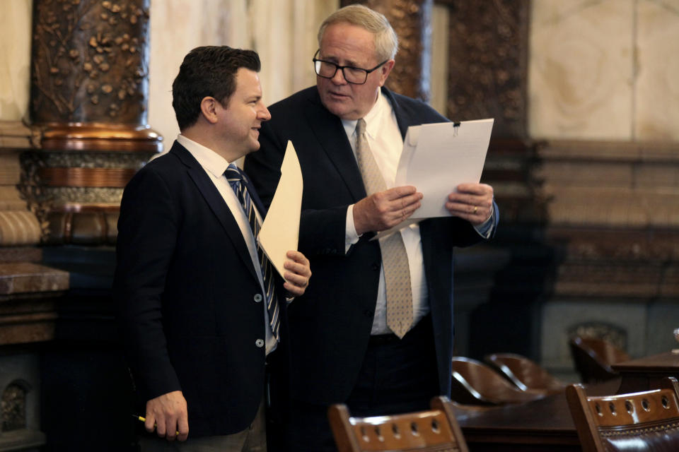 Kansas state Sens. J.R. Claeys, left, R-Salina, and Michael Fagg, right, R-El Dorado, confer ahead of a Senate session, Wednesday, Feb. 7, 2024, at the Statehouse in Topeka, Kan. Both senators have voted to force a debate on a proposed 93% pay raise for lawmakers next year, but that effort has failed, and the pay raise is set to take effect. (AP Photo/John Hanna)