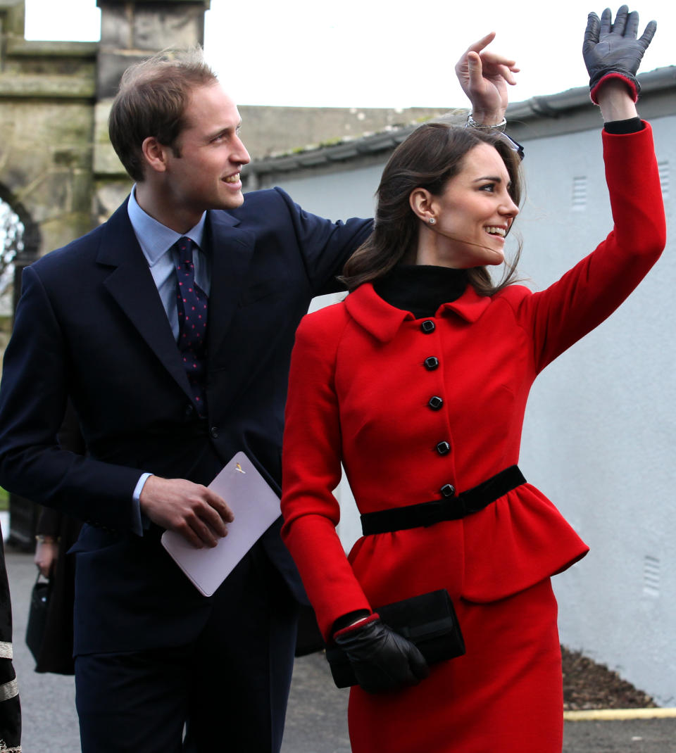 Prince William (L) and his fiancee Kate Middleton wave as they pass St Salvator's halls during a visit to the University of St Andrews in Scotland on February 25, 2011. During the visit they viewed the surviving Papal Bull (the university's founding document), unveiled a plaque, and met a selection of the Universitys current staff and students to mark the start of the Anniversary. Prince William and Kate Middleton attended the university as students from 2001 to 2005 and began their romance in St Andrews.2011. 
AFP PHOTO/WPA POOL/ANDREW MILLIGAN        (Photo credit should read ANDREW MILLIGAN/AFP/Getty Images)