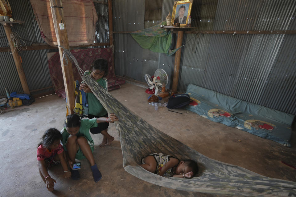 Children of Yem Srey Pin who moved from Cambodia's Angkor UNESCO World Heritage site, sit on the ground at their home in Run Ta Ek village in Siem Reap province, Cambodia, on April 2, 2024. Cambodia's program to relocate people living on the famous Angkor archaeological site is drawing international concern over possible human rights abuses, while authorities maintain they're doing nothing more than protecting the UNESCO World Heritage Site from illegal squatters. (AP Photo/Heng Sinith)