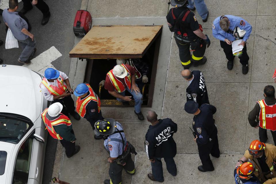 Metropolitan Transportation Authority (MTA) workers exit an emergency staircase after evacuating from a derailed F train in Woodside, New York, May 2, 2014. (REUTERS/Eduardo Munoz)