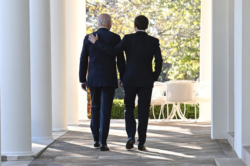 President Joe Biden and French President Emmanuel Macron walk along the Colonnade of the White House in Washington, Thursday, Dec. 1, 2022. (Jim Watson/Pool Photo via AP)
