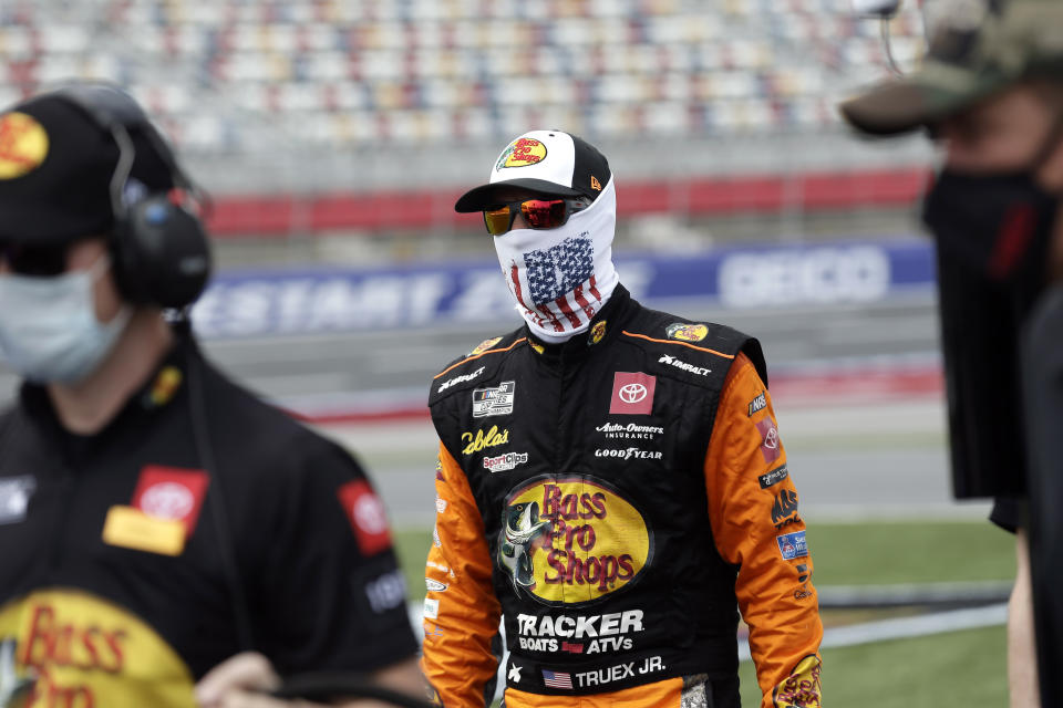 Driver Martin Truex Jr. walks to his car prior to qualifying for the NASCAR Cup Series auto race at Charlotte Motor Speedway Sunday, May 24, 2020, in Concord, N.C. (AP Photo/Gerry Broome)