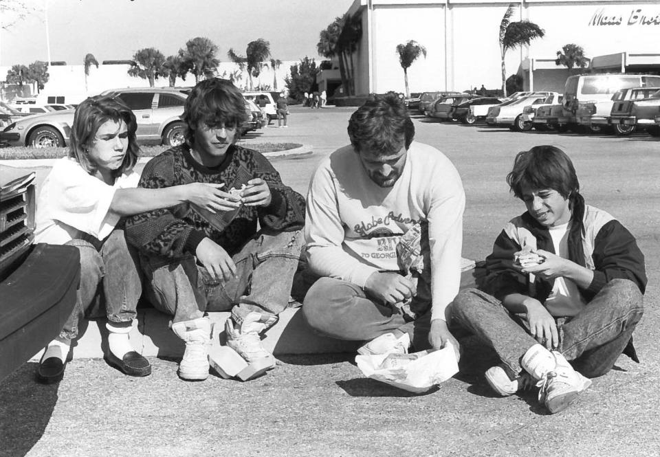 In this photo from the early 1990s, Christmas shoppers at the DeSoto Square Mall enjoy a lunch of hamburgers in the parking lot.