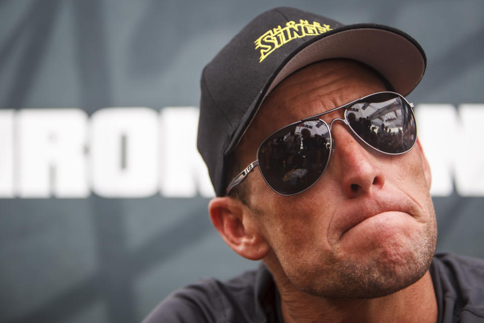 This April 1, 2012 file photo shows seven-time Tour de France champion Lance Armstrong grimacing during a news conference after the Memorial Hermann Ironman 70.3 Texas triathlon in Galveston, Texas. 