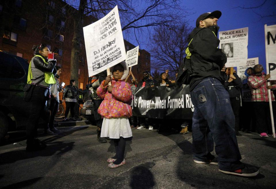 A young girl holds a sign at a portest against police violence in Boston