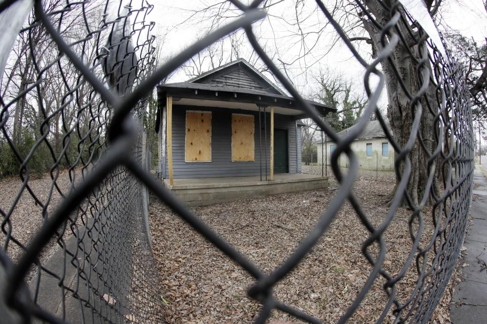 FILE - In this Jan. 16, 2017, file photo, the abandoned childhood home of singer Aretha Franklin sits behind a security fence in Memphis, Tenn. Recently, the Franklin birthplace and the surrounding neighborhoods have moved to the forefront of a large cleanup effort, as the city refuses to accept decay as a fact of life in the urban landscape. (AP Photo/Mark Humphrey, File)