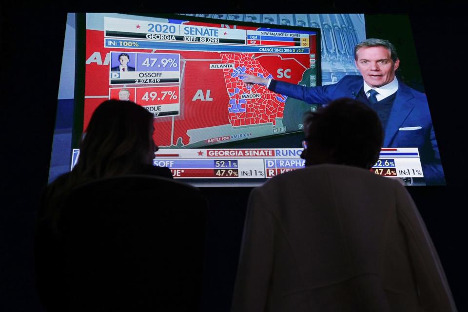 Hotel guests watch cable news reports about the 2020 election results for Georgia's senate run-off between Democrat Jon Ossoff and Republican David Perdue on January 5, 2021, in Atlanta, Georgia.