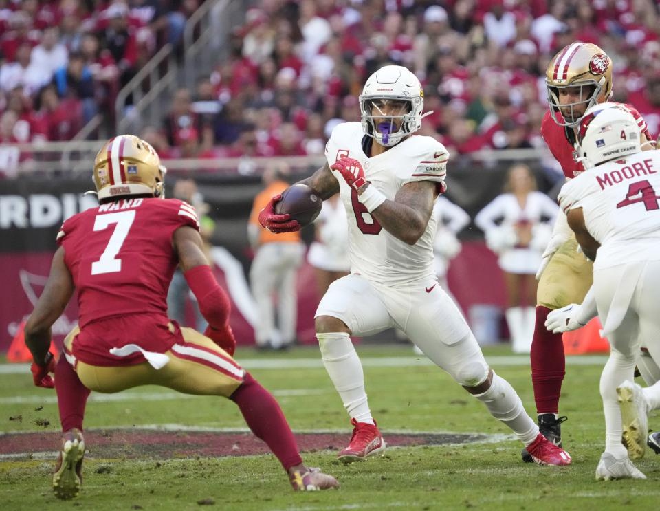 Arizona Cardinals running back James Conner (6) looks to get around San Francisco 49ers cornerback Charvarius Ward (7) during the second quarter at State Farm Stadium in Glendale on Dec. 17, 2023.