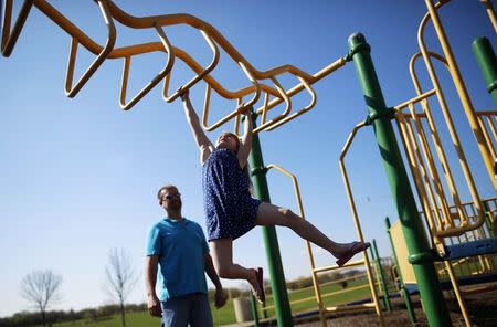 Joe Smith plays with his daughter Rowan at a playground in Winthrop Harbor, Illinois, May 9, 2014. REUTERS/Jim Young