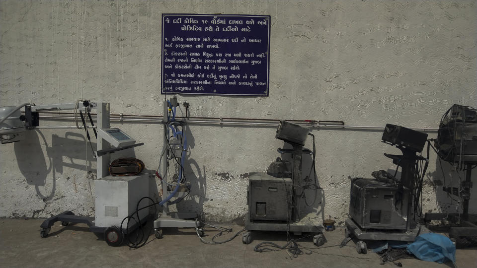 Instructions for COVID-19 patients are seen on a signage in Gujarati next to damaged equipments after a deadly fire at the Welfare Hospital in Bharuch, western India, Saturday, May 1, 2021. The fire in a COVID-19 ward of the hospital killed multiple patients early Saturday, as the country grappling with the worst outbreak yet steps up a vaccination drive for all its adults even though some states say don't have enough jabs. (AP Photo/Viral Rana)