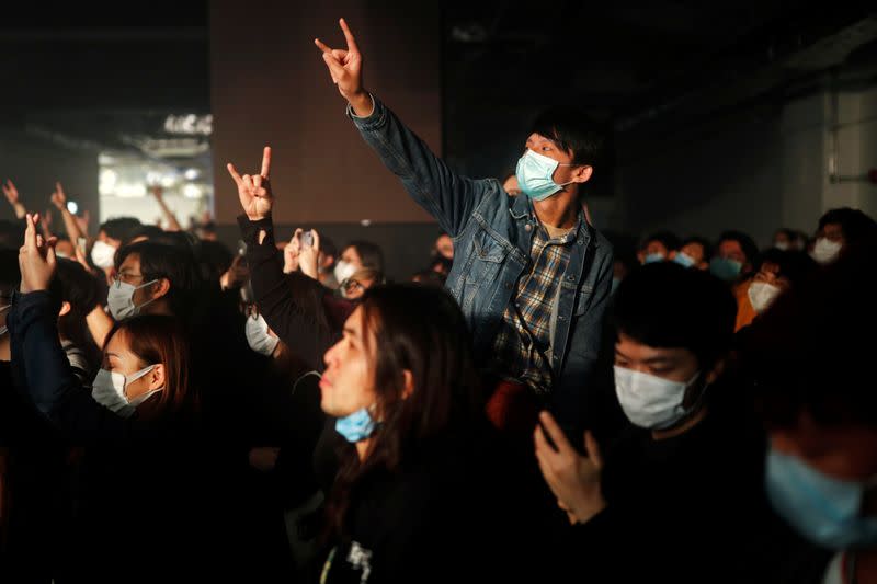 Fans wearing protective masks enjoy a band's performance at Hidden Agenda: This Town Needs (TNN) Live House during the club's last concert as business plummets due to the fear of the coronavirus, in Hong Kong