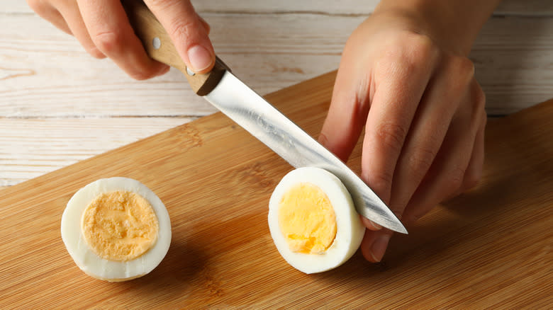 person slicing boiled eggs