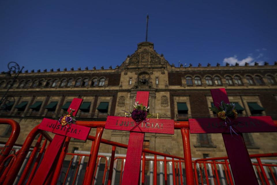 Red crosses with the Spanish word ‘Justice’ hang on the fence of the National Palace in Mexico, where they were placed by demonstrators holding an event coined a national mourning against femicides. (AP Photo/Fernando Llano)