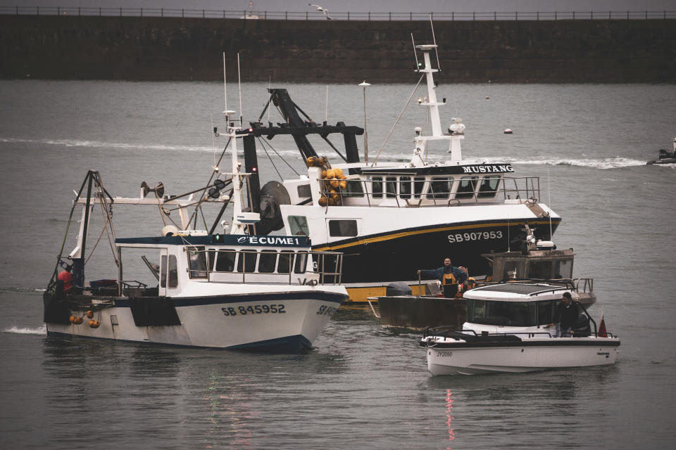 Fishing vessels at sea off a port in Jersey, Thursday, May 6, 2021. French fishermen angry over loss of access to waters off their coast have gathered their boats in protest off the English Channel island of Jersey. The head of a grouping of Normandy fishermen said about 50 boats from French ports joined the protest Thursday morning and gathered their fleet off the Jersey port of St. Helier. (Oliver Pinel via AP)