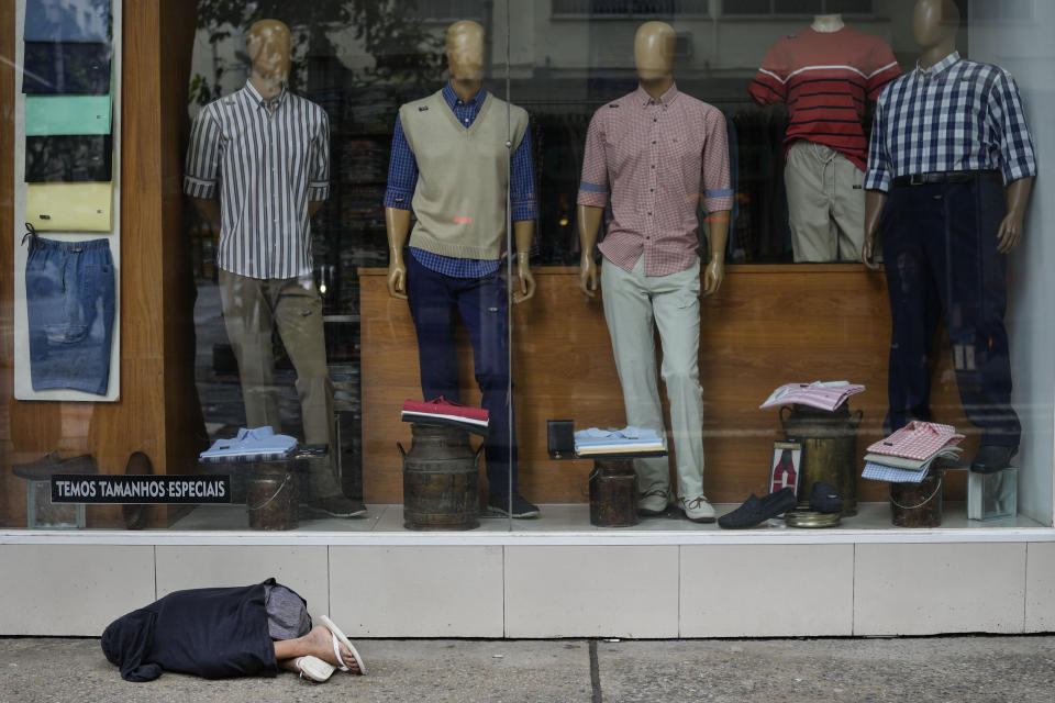 A homeless youth sleeps in front of a clothing store in the Copacabana neighborhood of Rio de Janeiro, Brazil, Friday, Sept. 30, 2022. Brazil will hold general elections on Oct. 2. (AP Photo/Matias Delacroix)