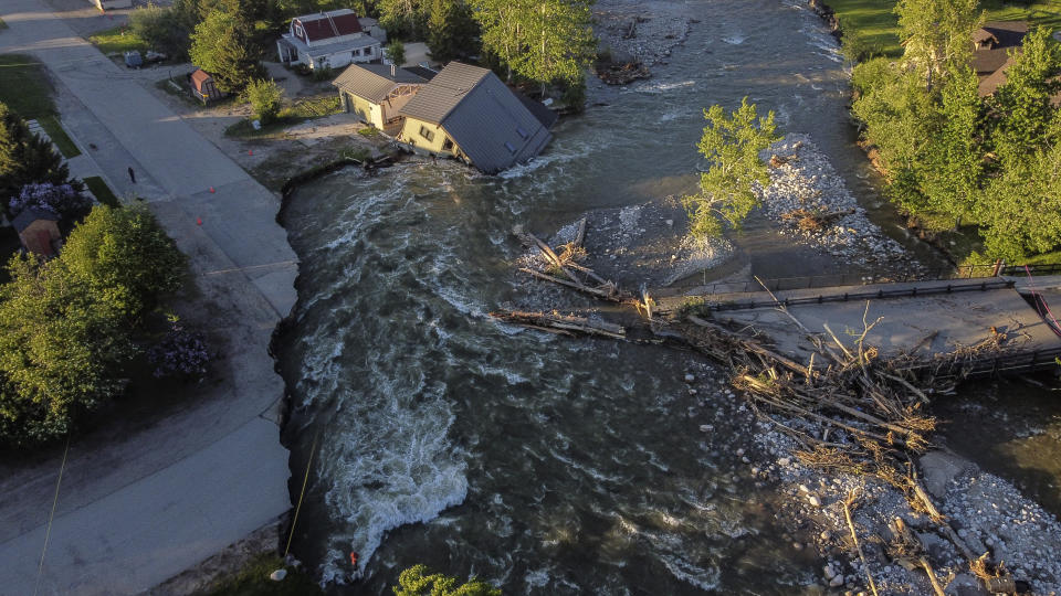 A house sits in Rock Creek after floodwaters washed away a road and a bridge in Red Lodge, Mont., Wednesday, June 15, 2022. (AP Photo/David Goldman)