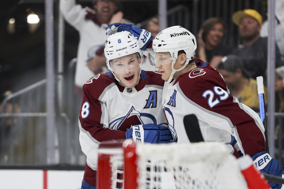 Colorado Avalanche defenseman Cale Makar (8) and center Nathan MacKinnon (29) celebrate after Makar's goal against the Vegas Golden Knights during the first period of an NHL hockey game, Sunday, April 14, 2024, in Las Vegas. (AP Photo/Ian Maule)